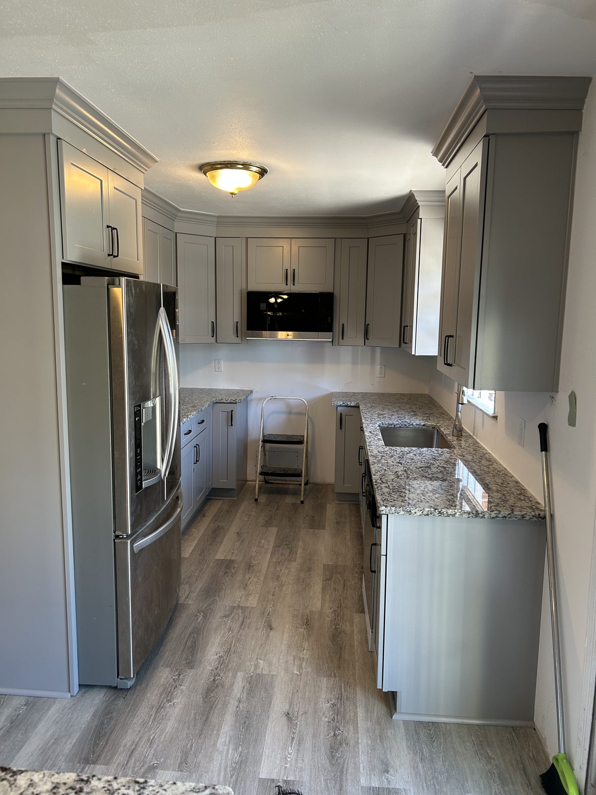 The finished kitchen with new grey shaker cabinets and granite countertops