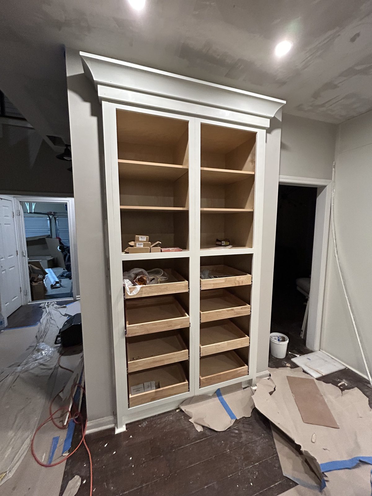 A new inset cabinet pantry with drawers and open shelving built where an old pantry was removed