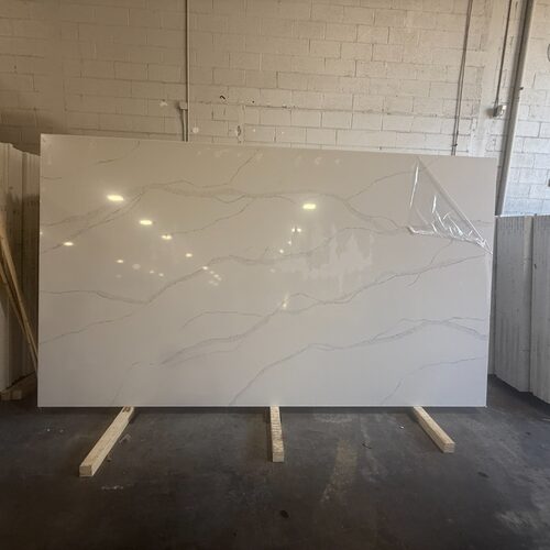 Calacatta Gold quartz slab close-up, polished white stone with grey veining